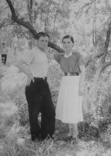 Mężczyzna i kobieta w strojach letnich stoją pod drzewem.