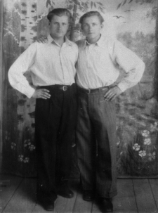 Dw&oacute;ch mężczyzn w koszulach na tle malowanego krajobrazu - Heniek i Wacek Karlukowie.