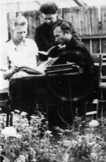 Więźniowie zwolnieni z łagrów. Trzech mężczyzn w ogródku, czytających książki. Od lewej: Stanisław Kiałka, Stanisław Kupraszewicz, Józef Krypajcis. Zdjęcie wykonane w 1955 lub 1956 roku.
