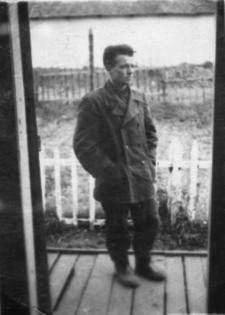 Stanisław Kupraszewicz, więzień łagrów. Fotografia wykonana w obozie nr 6, prawdopodobnie w 1953 roku. Mężczyzna stoi na tle krajobrazu.