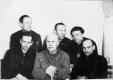 Więźniowie łagr&oacute;w. Sześciu mężczyzn siedzi we wnętrzu. Od lewej u dołu: Zbigniew Jasiński, Łusiak (komendant policji w Wilnie), J&oacute;zef Krypajcis; u g&oacute;ry: Stanisław Kupraszewicz, Piotr Adaś, Władysław Szarko. Zdjęcie z 1955 lub 1956 roku.