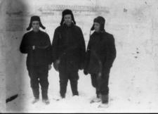 Więźniowie łagrów. Trzech mężczyzn w czapkach-uszankach na tle zimowego krajobrazu. Od lewej Ilkiewicz, Władysław Szarko, Stanisław Kupraszewicz. W tle most na rzece Workucie. Zdjęcie z 1955 lub 1956 roku.