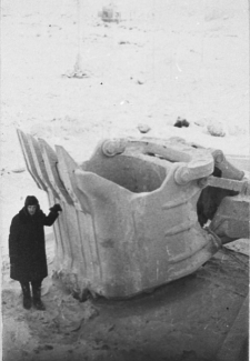 Fragment "Szanghaju". Mężczyzna w zimowym ubraniu obok czegoś, co wygląda na gigantyczną łyżkę koparki.