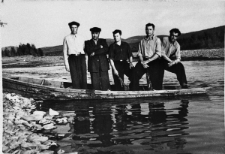 Pięciu mężczyzn w łódce na tle krajobrazu. Od lewej: Leon (nazwisko nieznane), NN, NN, Józef (nazwisko nieznane), NN. Zdjęcie wykonane w latach 1953-55, niedaleko kopalni złota.