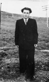 Jan Łukaszewicz. Zdjęcie wykonane prawdopodobnie po zwolnieniu z łagru (mężczyzna w garniturze na tle krajobrazu ze słupami telegraficznymi).