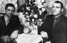 Jan Kriwel (po prawej), na przymusowej zsyłce po zwolnieniu z łagrów. Zdjęcie z 1955 lub 1956 roku - dwóch mężczyzn siedzi przu stole obok dużego bukietu.