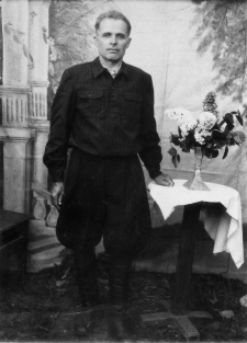 Józef Skorp, więzień łagrów. Zdjęcie z 1955 lub 1956 roku. Portret na tle malowanego widoczku.