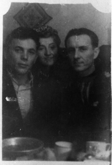 Troje ludzi za stołem. Od lewej: Julian Nowogródzki, nierozpoznana Polka, Stanisław Mogielnicki. Zdjęcie wykonane ok. roku 1954.