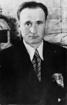 Stanisław Apanowicz - portret na tle zabudowań.