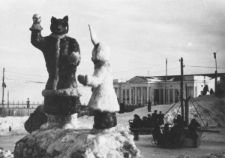 Ulica Magadanu w Nowy Rok. Na pierwszym planie rzeźba bajkowego wilka i zająca, z tyłu karuzela.