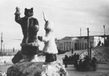 Ulica Magadanu w Nowy Rok. Na pierwszym planie rzeźba bajkowego wilka i zająca, z tyłu karuzela.