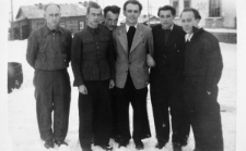 Grupa mężczyzn na tle drewnianych zabudowań. Stoją od lewej: Michał Horwat, Olgierd Zarzycki, Władek (nazwisko nieznane), Edward Muszyński, NN, NN.