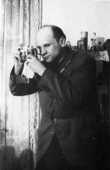 Paweł Świetlikowski - portret z aparatem fotograficznym.