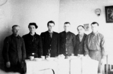 Grupa mężczyzn stojących za stołem.