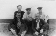 Pięciu mężczyzn siedzących na ziemi.