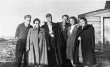 Grupa ludzi obok drewnianego budynku. W środku stoją: Olgierd Zarzycki i Wiktor Jagoda, pozostałe osoby NN.