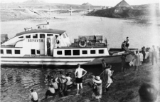 Statek wycieczkowy na rzece Workucie w okolicach Workuty. W głębi hałdy węgla wokół kopalni.