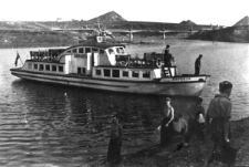 Statek wycieczkowy na rzece Workucie w okolicach Workuty. W głębi hałdy węgla wokół kopalni.