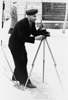 Wojciech Zakrzewski nastawiający aparat fotograficzny na statywie.