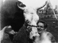 Mężczyzna przytulający twarz do pyska rogatego zwierzęcia - Wojciech Zakrzewski z bykiem.