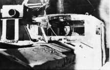 Mężczyzna w stroju górnika w kabinie dużej maszyny.