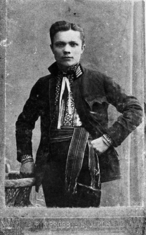 Portret młodego mężczyzny w ludowej koszuli i przepasanego krajką.