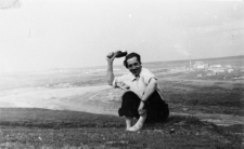 Mężczyzna siedzący na tle krajobrazu.