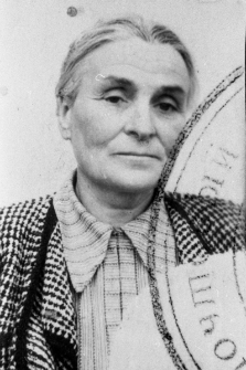 Zdjęcie legitymacyjne - portret straszej kobiety, z prawej strony fragment urzędowej pieczęci.