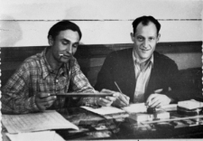 Henryk Stawryłło (z prawej) w radzieckim łagrze - dwóch mężczyzn za stołem z przyborami do pisania.