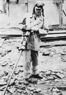 Eugeniusz Nadziejko w stroju górnika, przed kopalnią, zdjęcie z 1954-55 roku.