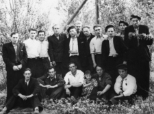 Więźniowie łagru; grupa mężczyzn na tle zarośli, trzeci od lewej siedzi: Witold Juchniewicz, czwarty z lewej stoi: Romuald Kononowicz, z tyłu stoi: Stanisław Lelewicz. Pozostałe osoby NN, Ukraińcy.
