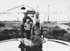 Polacy, więźniowie łagru obok obozowej fontanny. Od lewej: Zygmunt Olechnowicz, Eugeniusz Nadziejko, NN (Polak z Łotwy). W tle mur i zabudowania.