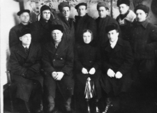 Więźniowie zwolnieni z łagrów w oczekiwaniu na wyjazd do Polski. Grupa ludzi we wnętrzu. Od lewej siedzą: NN, Gustaw Angielski, NN (żona Romualda Orskiego, Rosjanka), Romuald Orski. Stoją od lewej: NN, NN, Witold Stefanowicz, Romuald Kononowicz, Stanisław Juchniewicz, NN, NN. Zdjęcie prawdopodobnie z 1956 roku.