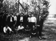 Więźniowie łagru. Grupa mężczyzn na tle drzew. Czwarty od lewej stoi: Romuald Kononowicz, szósty: Stanisław Lelewicz; pozostałe osoby nierozpoznane. Zdjęcie wykonane prawdopodobnie w 1954 lub 1955 roku.