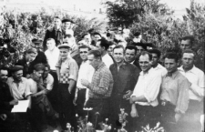 Duża grupa ludzi wśród zarośli. Ksiądz Wilmański (pierwszy od lewej), Hubert Bartoszewicz (czwarty od lewej), Zygmunt Olechnowicz (który?), pozostali nierozpoznani; zdjęcie z 1954-55 roku.