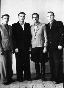 Czterech mężczyzn stojących przy ścianie. Romuald Kononowicz (pierwszy od prawej) po zwolnieniu z łagru, razem z kolegami z obozu (Ukraińcy, NN), we wspólnie zamieszkiwanym pokoju.
