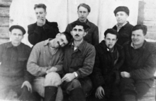 Grupa mężczyzn na tle drewnianej ściany. Drugi od lewej: Stanisław Niedźwiecki, Dorożko (kt&oacute;ry?), pozostali nierozpoznani. Wigilia prawdopodobnie 1954 roku.