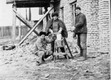 Na przymusowej zsyłce. Trzech mężczyzn w strojach roboczych przy ostrzałce, pierwszy z prawej: Bolesław Kratus.