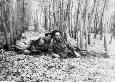 Dwóch mężczyzn leży w trawie między drzewami. Bolesław Kratus (pierwszy od prawej) po wyjściu z obozu; druga osoba nierozpoznana.