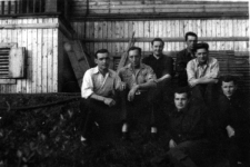 Grupa mężczyzn przed drewnianym budynkiem. Drugi od lewej: Wasilewski, drugi od prawej Eryk Barcz (Lech Kożuchowski).