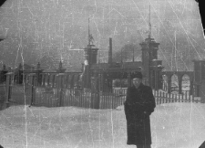 Bernard Grzywacz przed bramą stadionu sportowego wybudowanego przez więźniów.