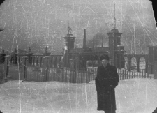 Bernard Grzywacz przed bramą stadionu sportowego wybudowanego przez więźniów.