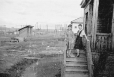 Dwie kobiety na schodach przed barakiem.