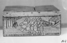 Pudełko wykonane z drewna przez nieznanego więźnia obozu. Napisy na pudełku: "Do najulubieńszych rozrywek należało saneczkowanie".