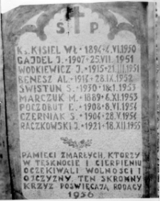 Tablica na krzyżu, napis: "Pamięci zmarłych, kt&oacute;rzy w tęsknocie i cierpieniu oczekiwali wolności i ojczyzny, ten skromny krzyż poświęcają rodacy"; nazwiska: Ks. Kisiel Wł., J. Gajdel, J. W&oacute;dkiewicz, Al. Benesz, S. Świstun, M. Marczuk, E. Poczobut, S. Czerniak, J. Raczkowski".