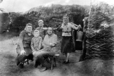 Siedzą od lewej: Maria Wierzba - żona policjanta z okolic Stanisławowa, jej syn Mietek, Leopoldyna Urbanowska, chrzestna A. Wandurskiego z Sołotwiny; stoją: Andrzej Wandurski i jego matka Zofia (z wiadrami na koromyśle). W tle wejście do sieni o wiklinowych ścianach, za nią znajdowała się zagłębiona w ziemi izba mieszkalna. Zdjęcie wykonane nielegalnie przez enkawudowskiego fotografa przy okazji wyrabiania sowieckich paszportów.