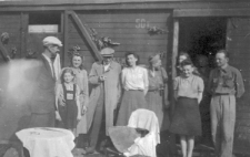 Odjazd transportu repatriantów, grupa osób przed wagonem towarowym.