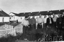Grupa mężczyzn (przed lub po zwolnieniu z łagru) na tle obozu przy kopalni I Kapitalna.