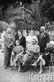 Grupa os&oacute;b pod palmą.