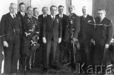 Dwaj oficerowie i kilku mężczyzn w garniturach, w środku stoi Henryk Józewski.